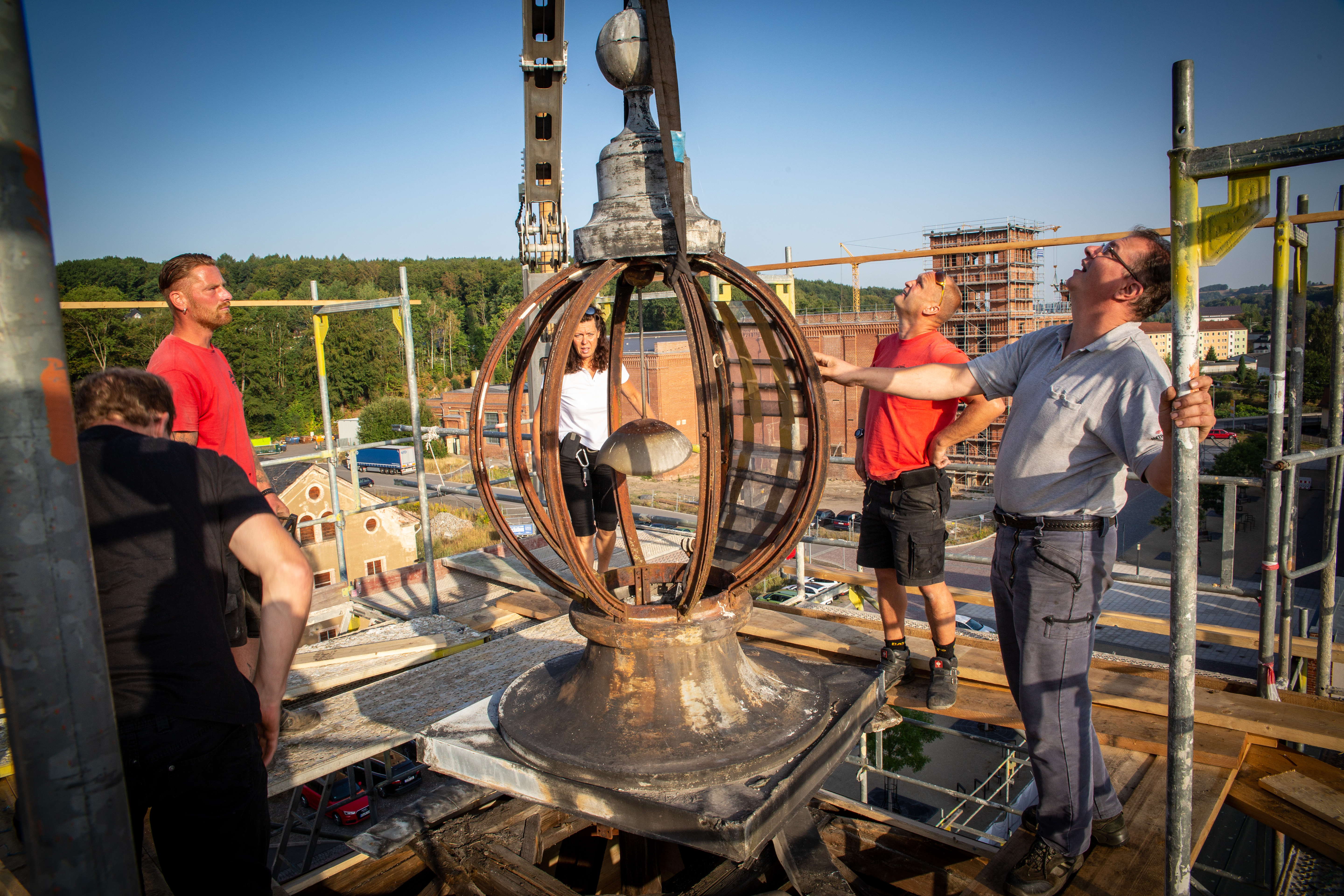 hfj, Flöha, 09.08.2018 Glaskuppel schwebt Die Glaskuppel auf der Dachspitze des Türmchens des früheren Verwaltungsgebäudes der Baumwollspinnerei Flöha wurde am Morgen des 9.August abgenommen. Diese soll in den nächsten Wochen in der Werkstatt von Metallbaumeister und Kunstschmied Thomas Koch aus Burgstädt gemeinsam mit Restaurator Lars Ehrhardt restauriert werden. Bereits am Vortag hatten die beiden Handwerker die Vorarbeiten in luftiger Höhe absolviert, so dass der Kran, geführt von Ronny Jansen von der Dachdeckerei Tillmann, kurz nach 07.30 Uhr die Kugel vorsichtig zunächst in die Höhe und dann auf ein Fahrzeug heben konnte. Die Glaskuppel wird nach der Sanierung wieder auf dem Dach des 1902 eingeweihten Verwaltungsgebäude der Baumwollspinnerei leuchten. Nach der Sanierung soll das Gebäude das Rathaus der Stadt Flöha beherbergen.