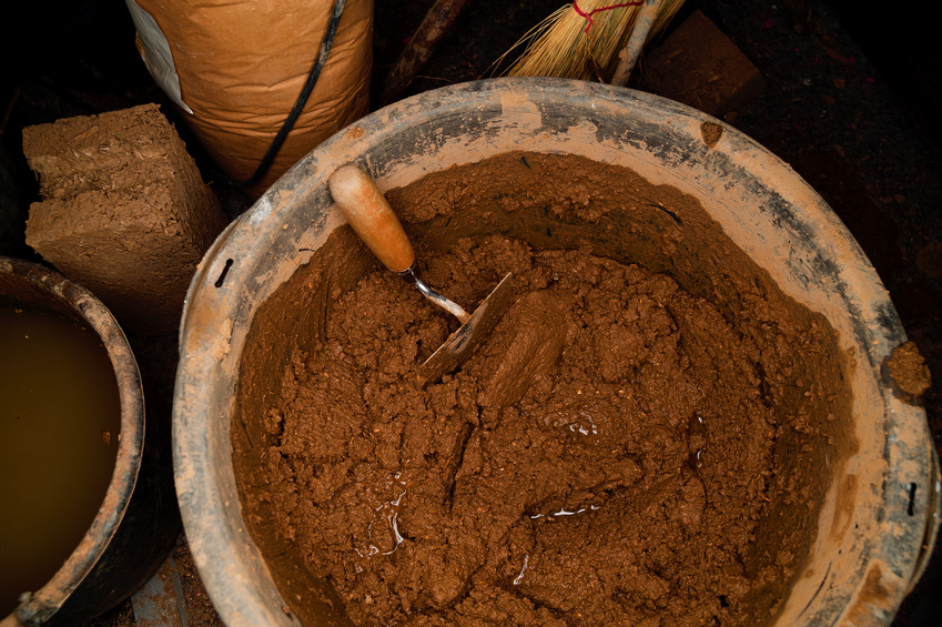 Eine Schüssel mit einer Lehmmischung für den Lehmbau (A bowl with a clay mixture for the clay building)